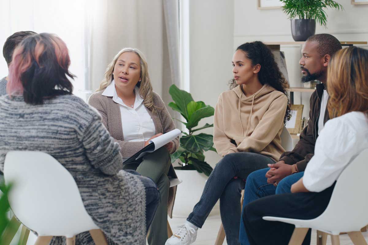 individuals in group therapy for addiction discuss how their intensive outpatient program has benefited them