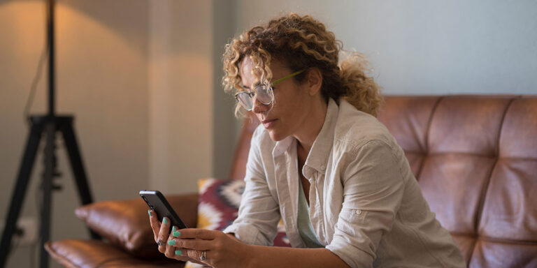 person sitting on couch using phone to research detox at home