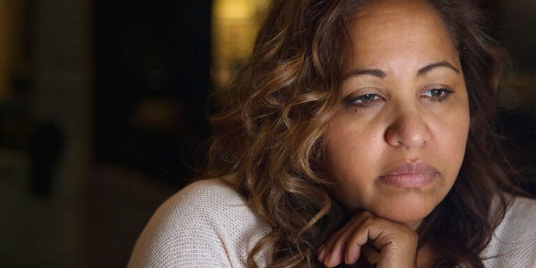 woman with head on hand considers opioid withdrawal symptoms