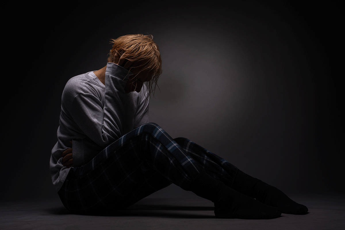 person with head in hands working through the physical signs of meth addiction
