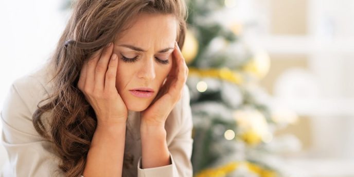 woman sitting by tree considers avoiding relapse during the holidays