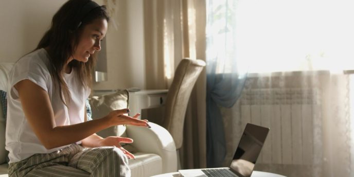 woman talking on laptop in virtual addiction treatment