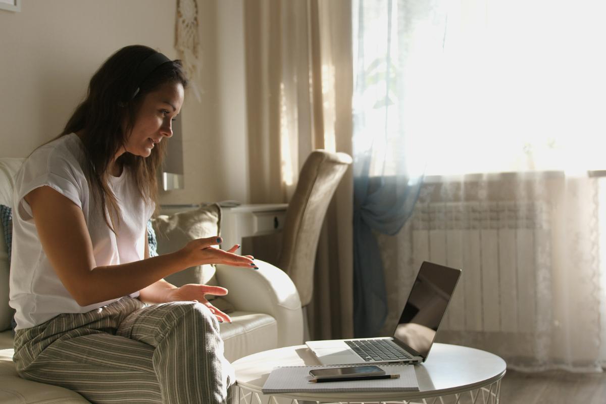 woman talking on laptop in virtual addiction treatment