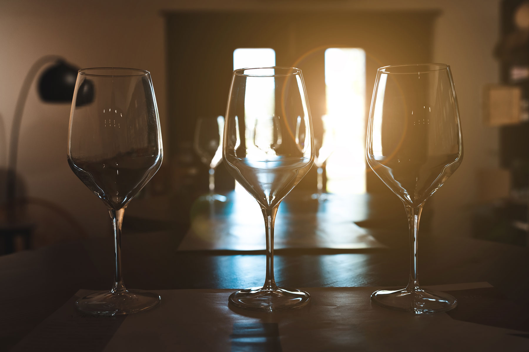 three empty wine glasses on bar left by person who needs vivitrol for alcohol use disorder