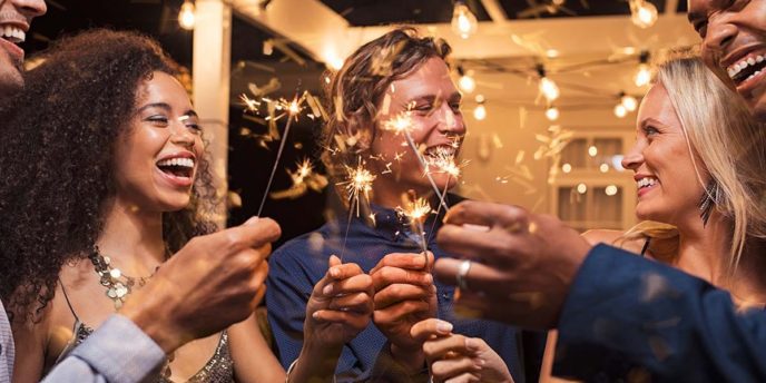 people laughing with sparklers about how to have a sober new year's eve