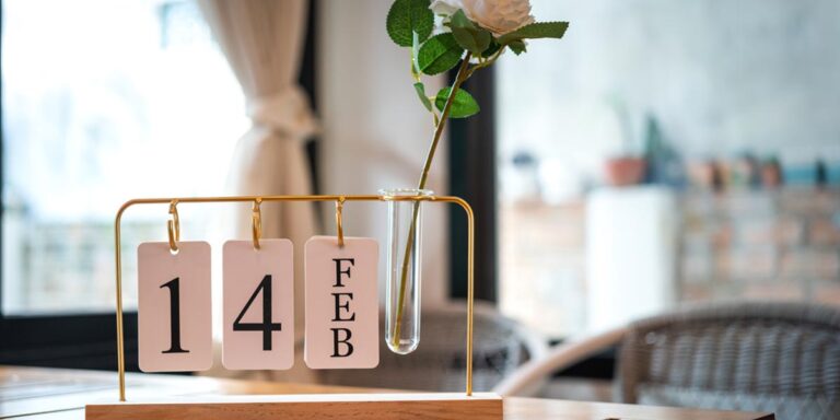 Calendar on table in rehab center displaying the date February 14th with a white rose to celebrate Valentine's Day in addiction recovery