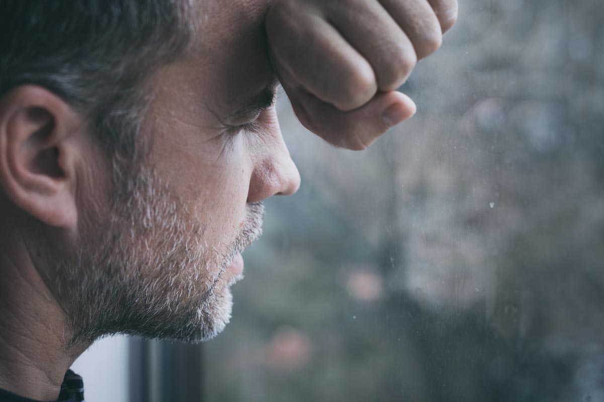 Men facing window with eyes closed contemplating the question how long does it take to become dependent on opioids