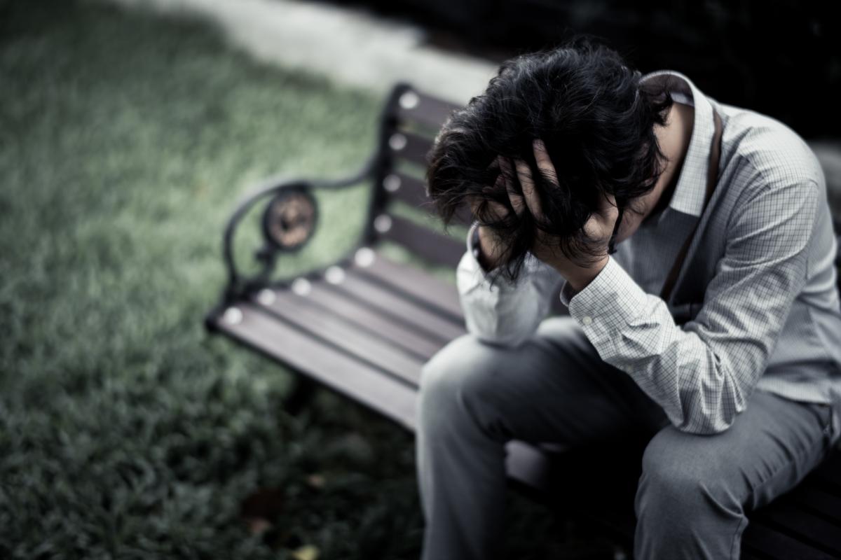 Person on park bench with his head in his hands wondering about vivitrol side effects