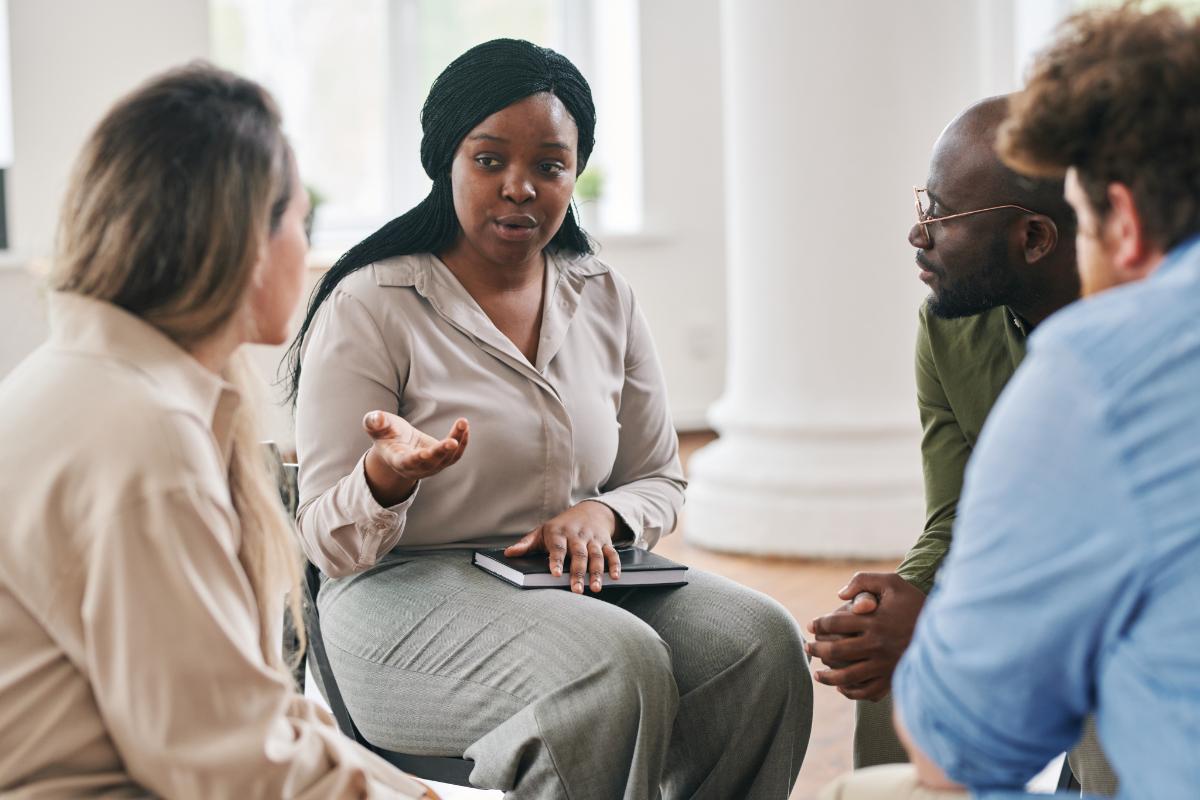 Woman speaking to therapy group in drug rehab near brockton ma