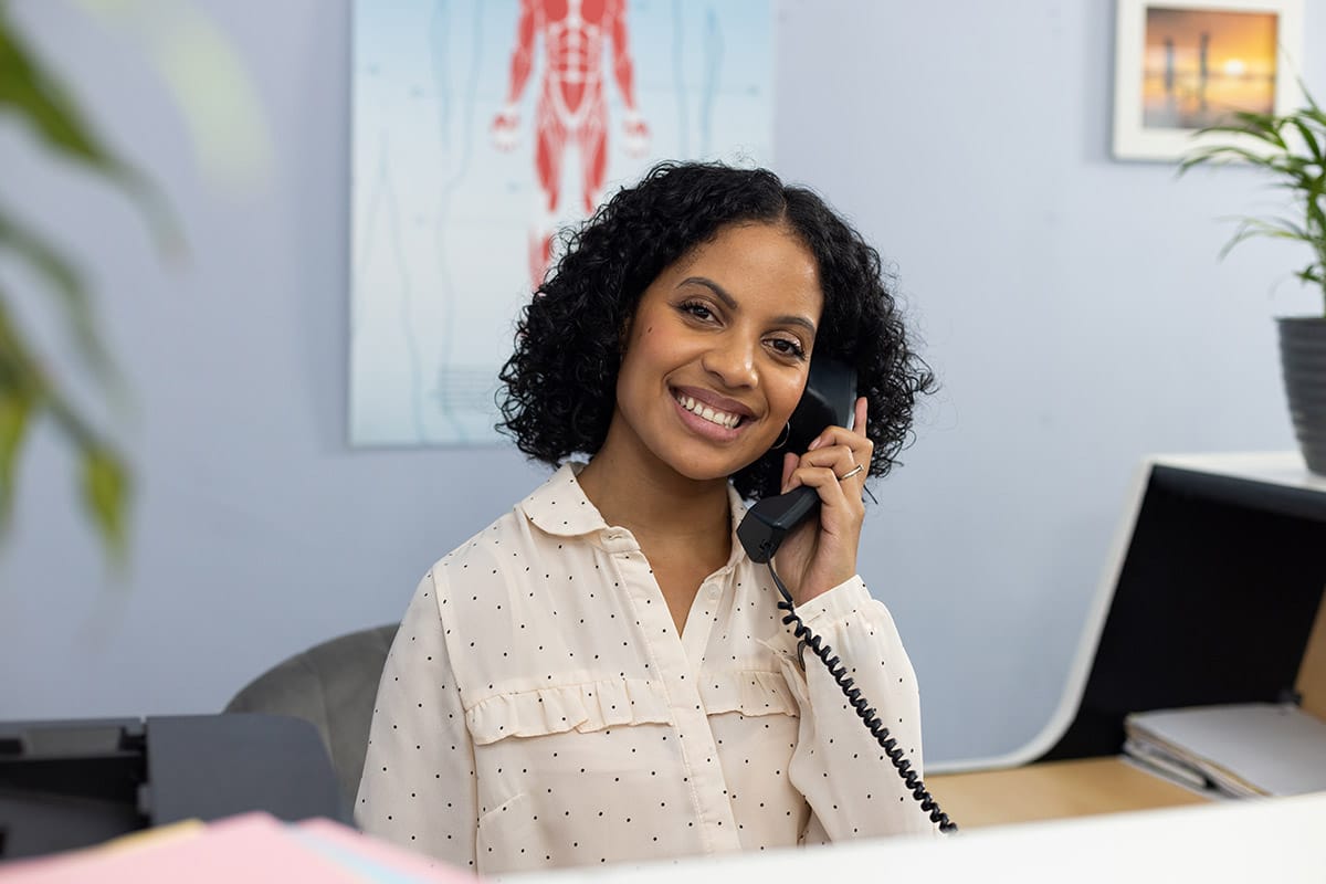 Intake specialist smiling while on the phone with a patient in a suboxone clinic in glasgow ky