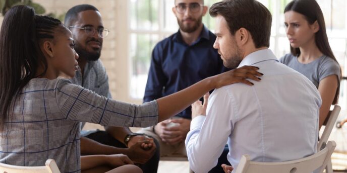 Group of diverse people talking and comforting one another in group therapy in outpatient addiction treatment near boston ma