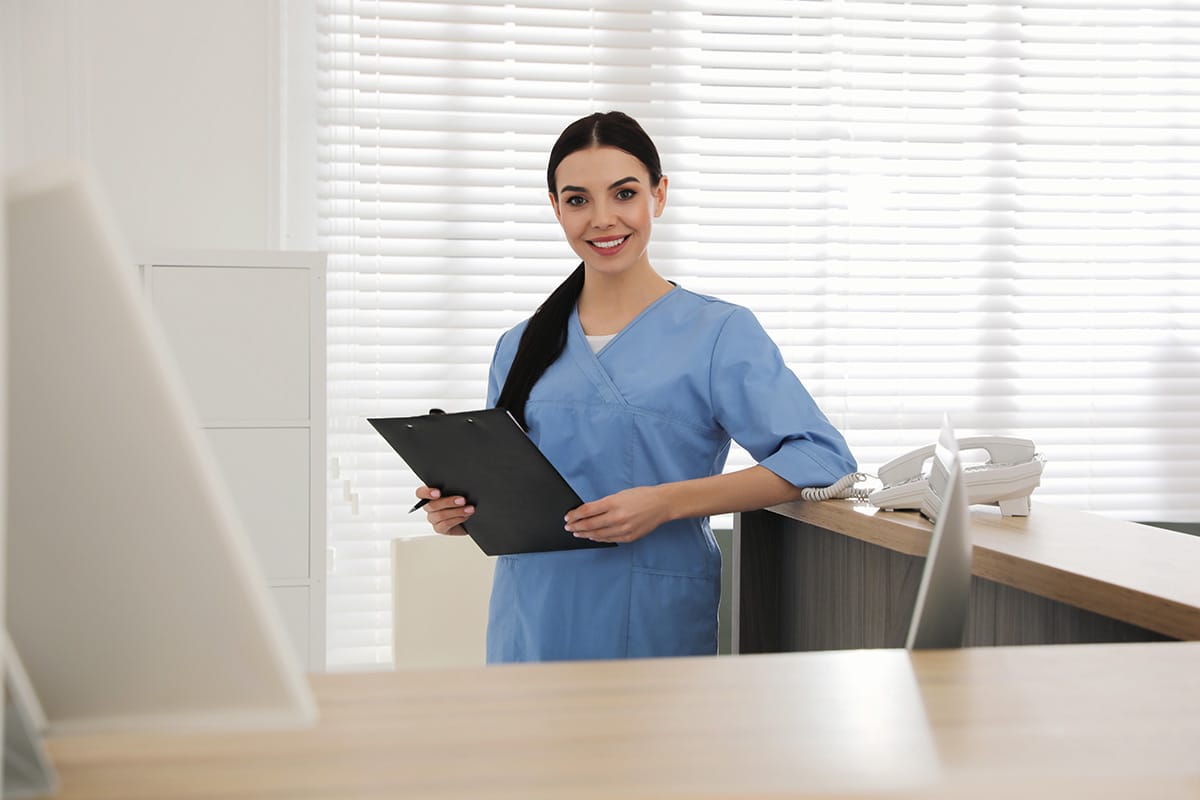 Intake nurse smiling and holding a clipboard at a suboxone clinic in henderson ky