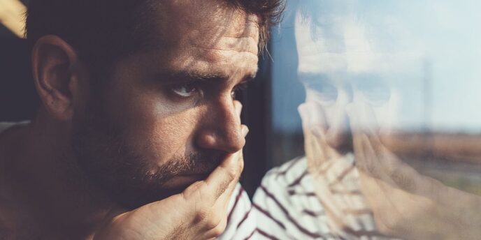 Person looking out of window in despair while experiencing signs of suboxone abuse