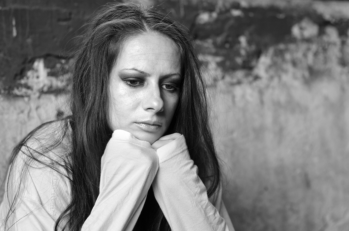 black and white photo of person resting chin against fists looking distressed while contemplating how long do withdrawals last