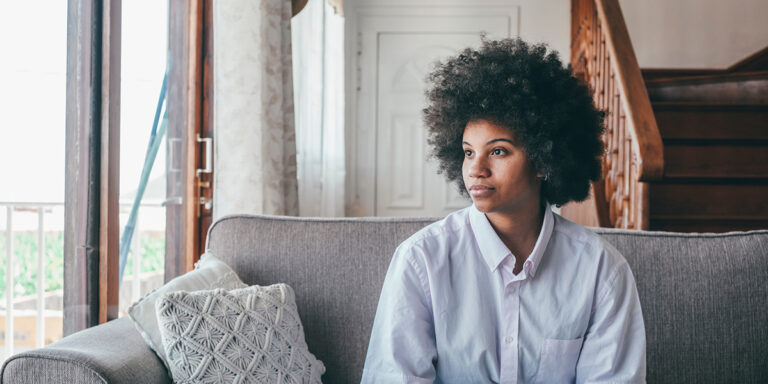 person on couch looking out window while considering hydrocodone withdrawal symptoms