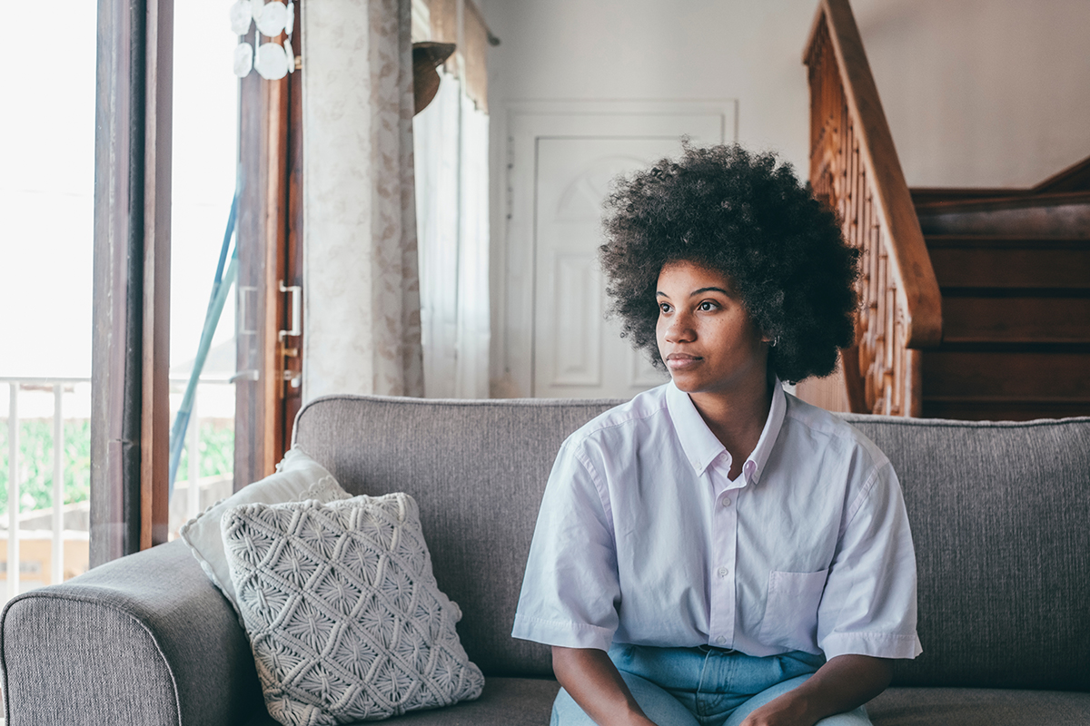 person on couch looking out window while considering hydrocodone withdrawal symptoms