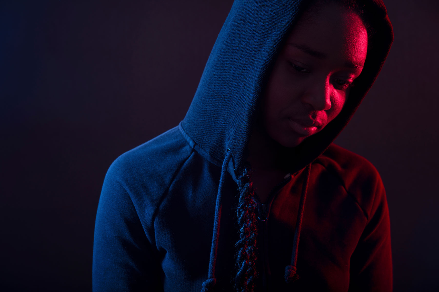 person in hoodie in the dark looking distressed while wondering how to overcome fentanyl addiction