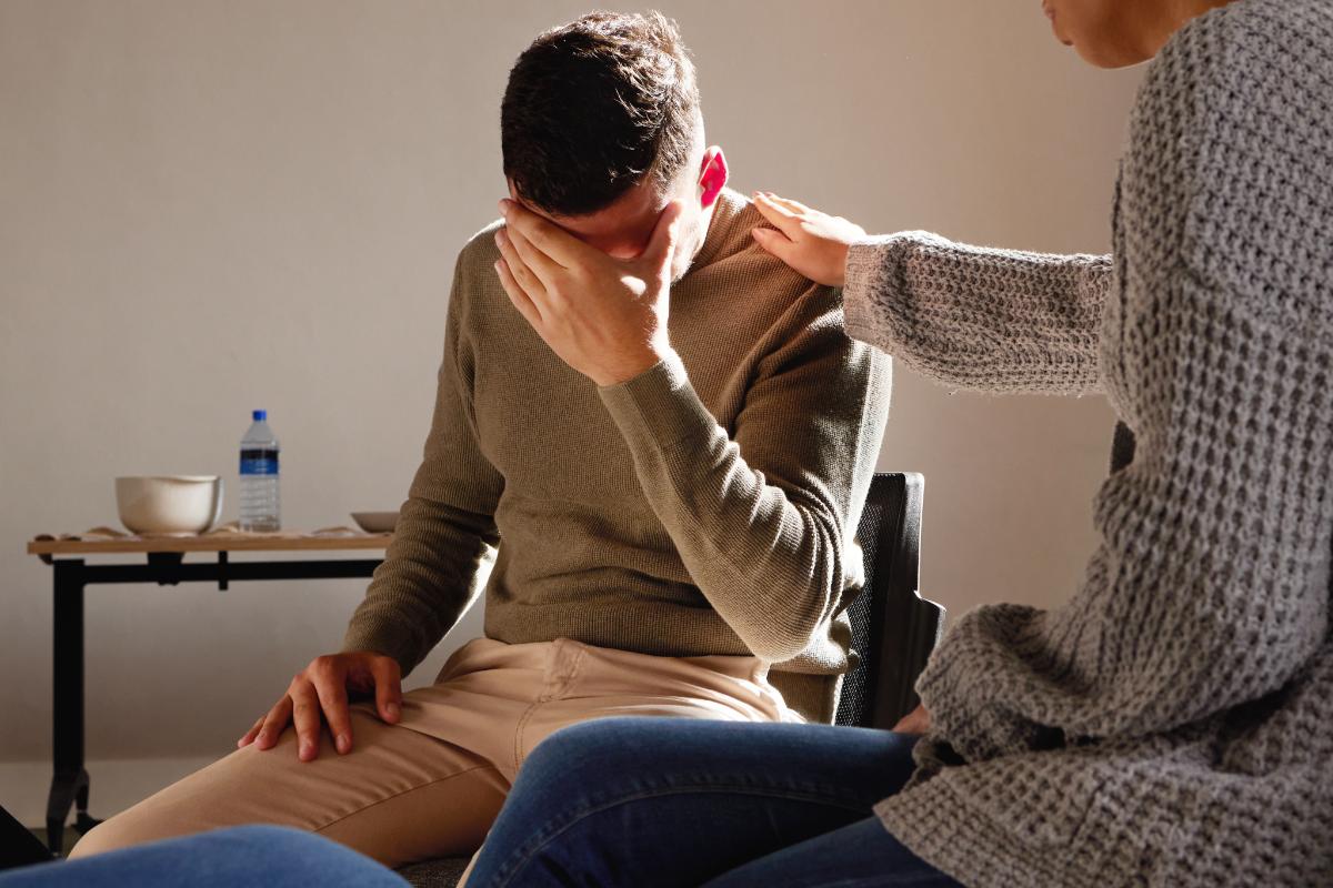 person handing head and being comforted by another person after learning how long do withdrawals last