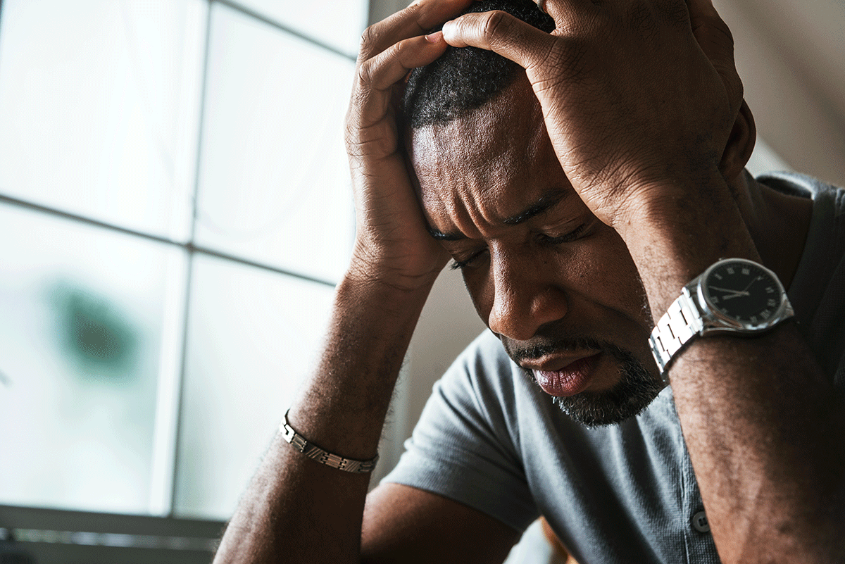 person hanging head while showing signs of addiction relapse
