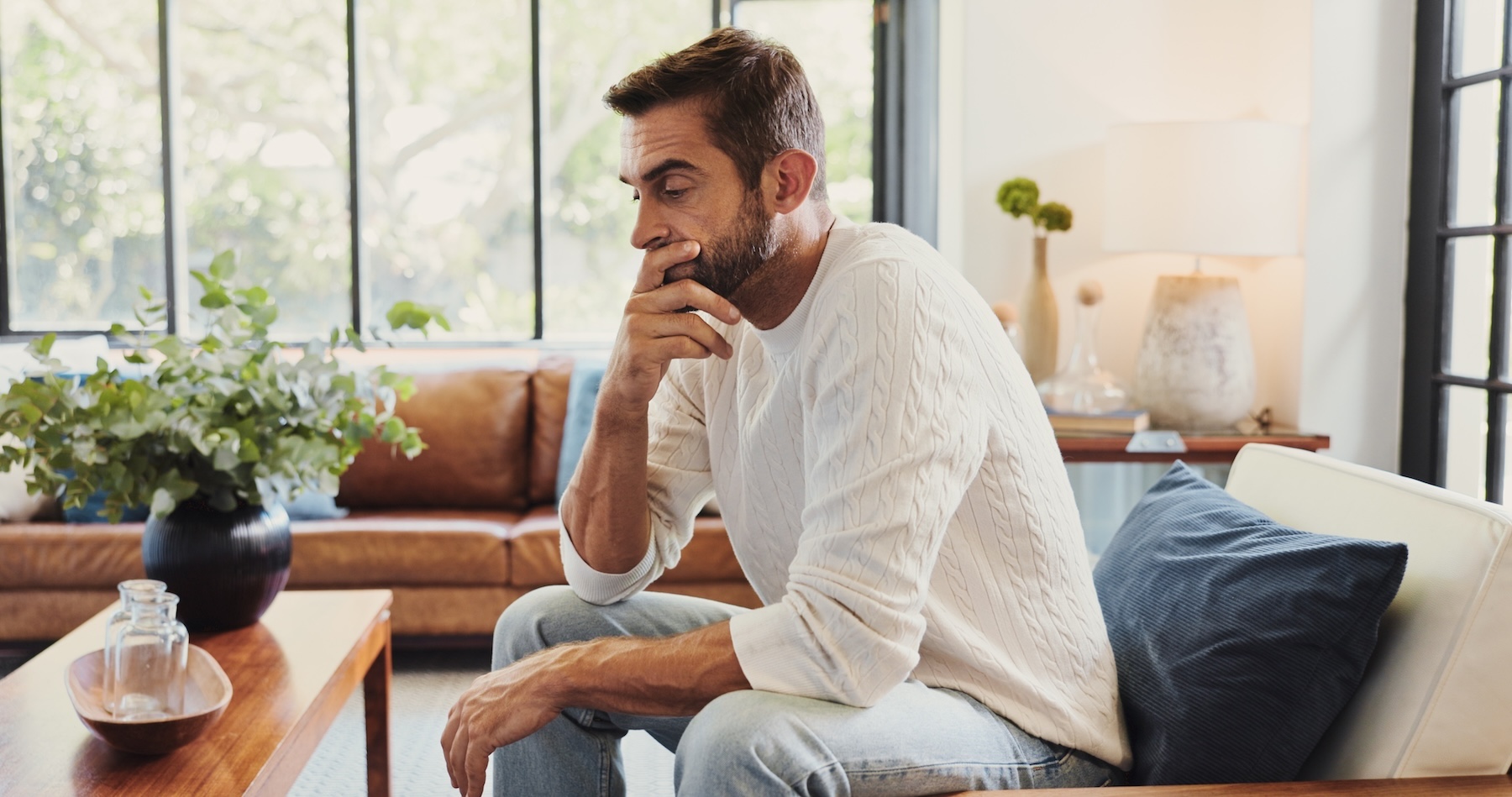 Thinking, crisis and man in home with stress for bankruptcy, financial challenge or difficult decision. Sad, worry and person with concern for doubt, mistake or debt with reflection for mental health