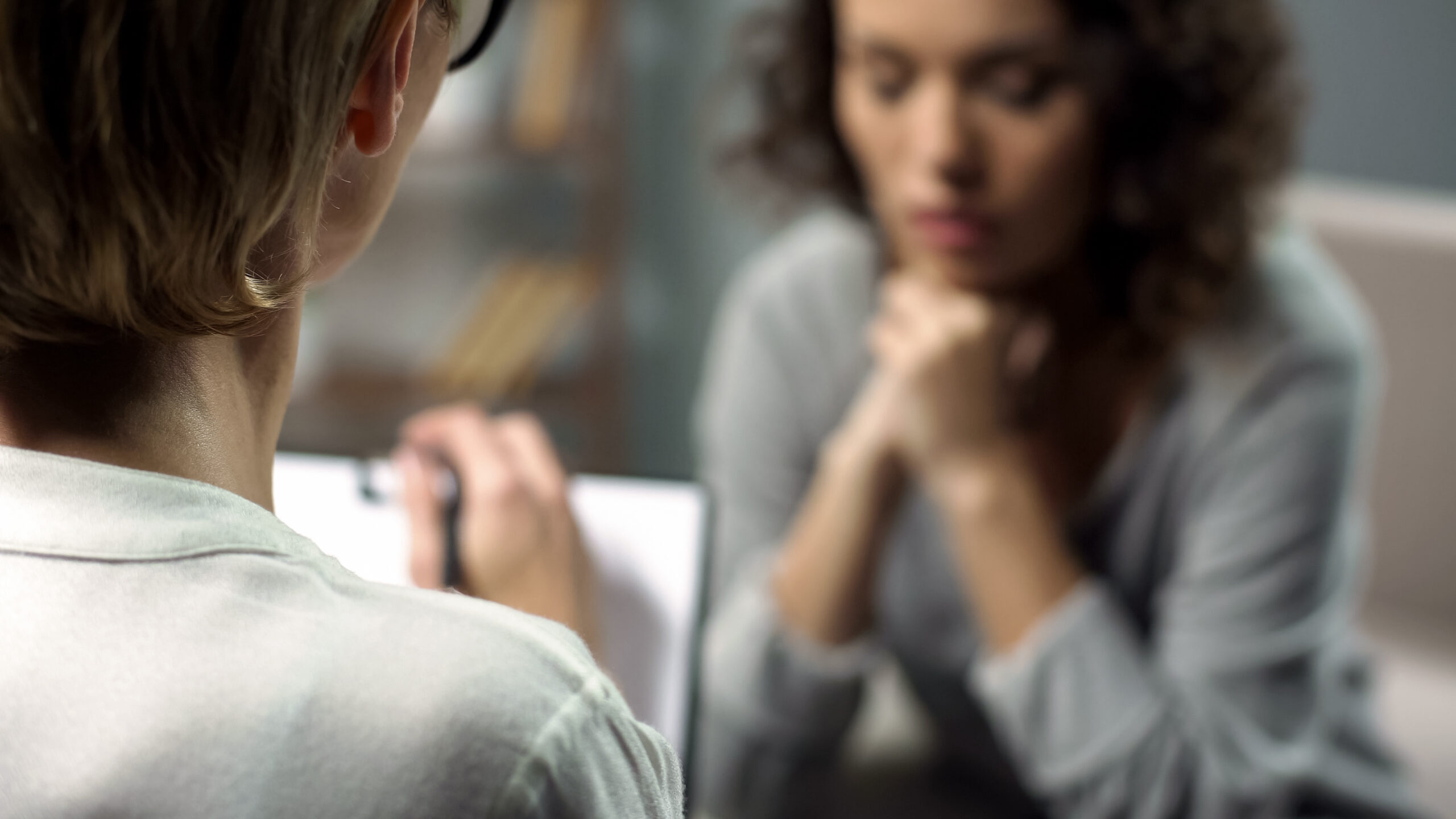 Young depressed woman talking to lady psychologist during sessio