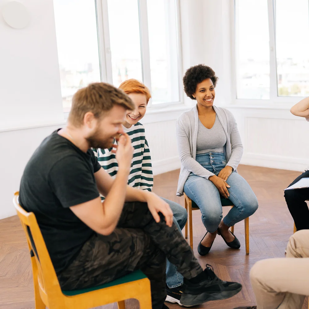 People laughing in group therapy